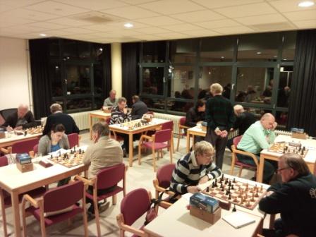 Een gezellige speelzaal vol met schaakleden